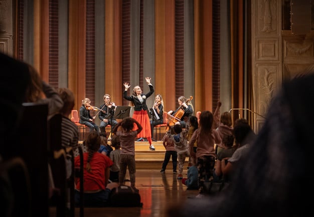 Barn som tittar på musiker. Fotografi.