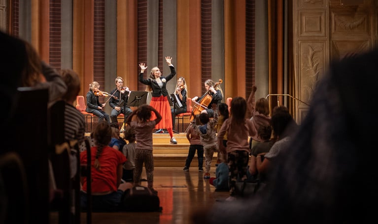 Barn som tittar på musiker. Fotografi.