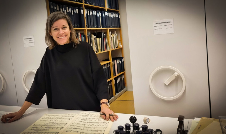 Leende kvinna som jobbar på notbiblioteket.. Fotografi.