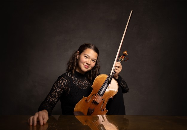 Porträttbild på en leende kvinna med violin. Fotografi.