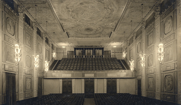 Bild på Grünewaldsalen, från scenen sett, en vacker utsmyckad sal målad av Isaac Grünewald. Äldre svart-vitt fotografi.