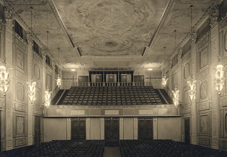 Bild på Grünewaldsalen, från scenen sett, en vacker utsmyckad sal målad av Isaac Grünewald. Äldre svart-vitt fotografi.