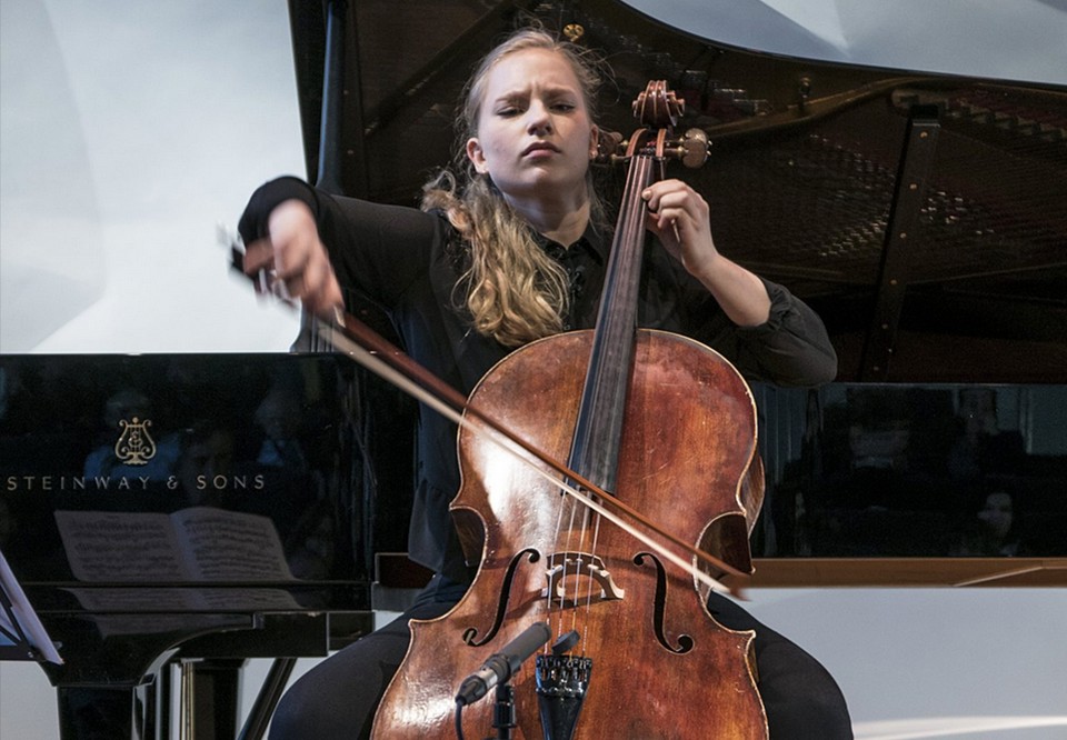 Kvinna som spelar cello. Fotografi.