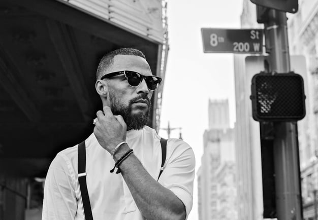 Rap artist ADL wearing sun glasses in a New York City street environment. Black and white photography.