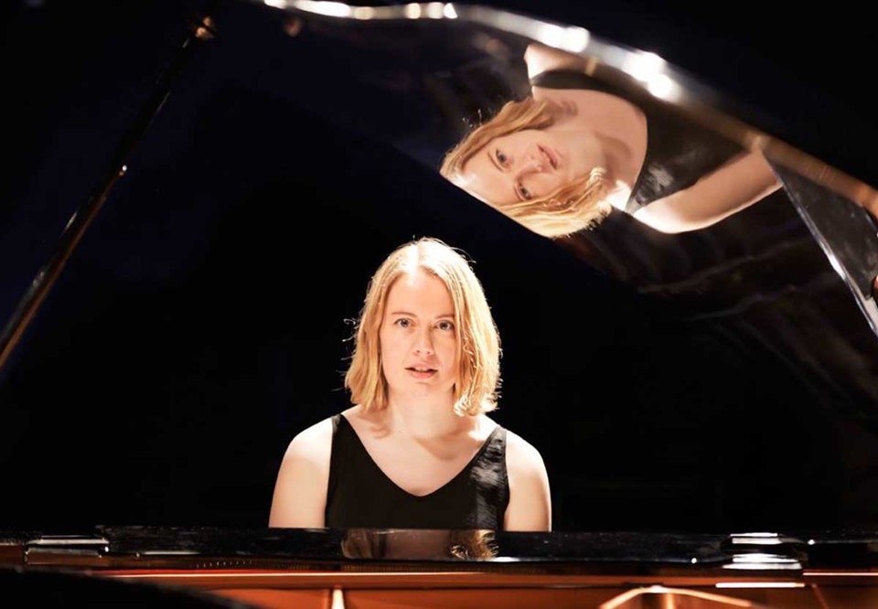 Porträttbild av Anna vid sitt piano. Fotografi