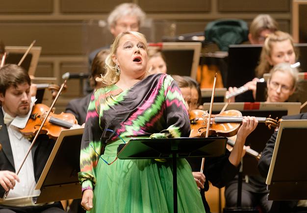 Woman singing in front of the orchestra. Photography.