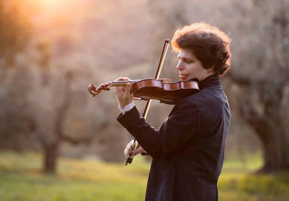 Man som spelar violin. Fotografi.