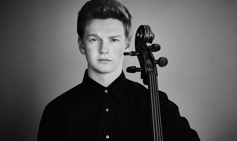 Nörbild på ung kille med cello. Fotografi.