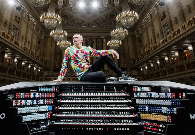 Young guy sitting on a organ. Photo