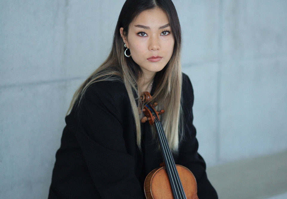 Kvinna som håller i en violin. Fotografi.