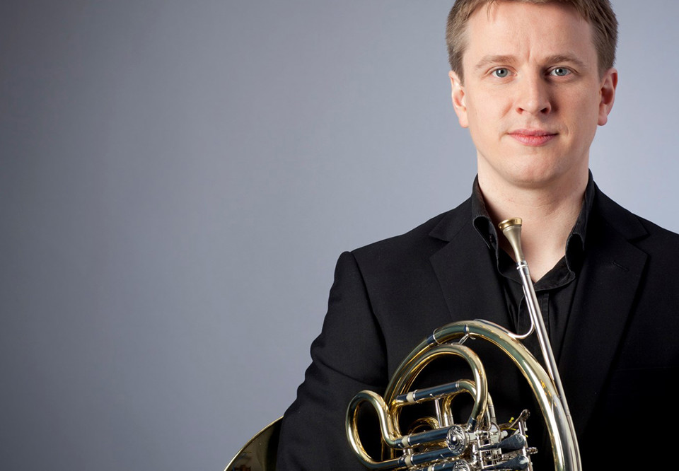 Man stående med horn under armen