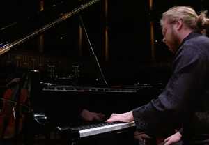 Man sitting by a piano. Photo.