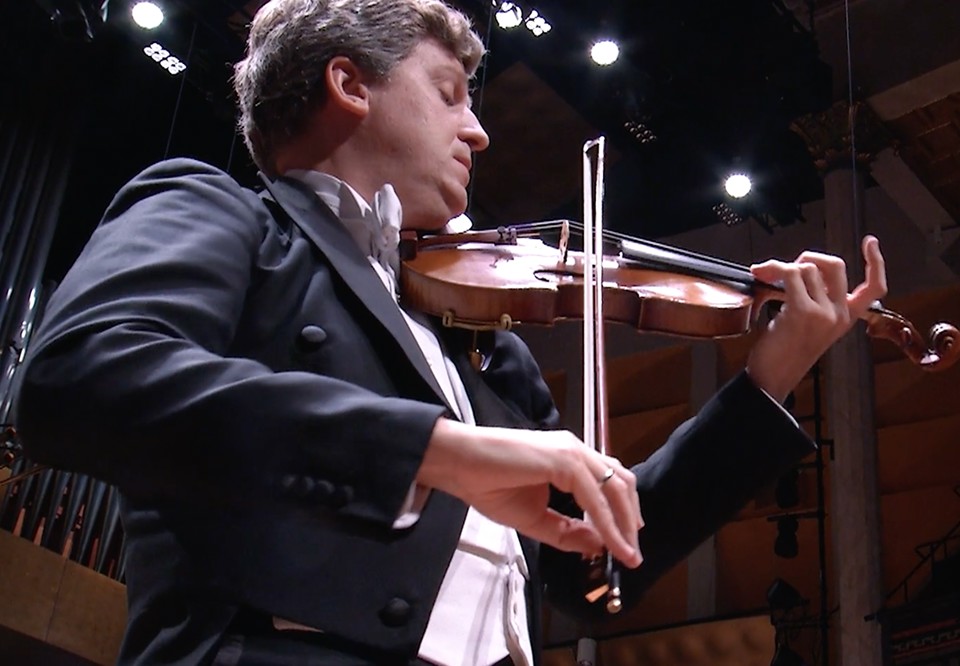 Man som spelar violin. Fotografi