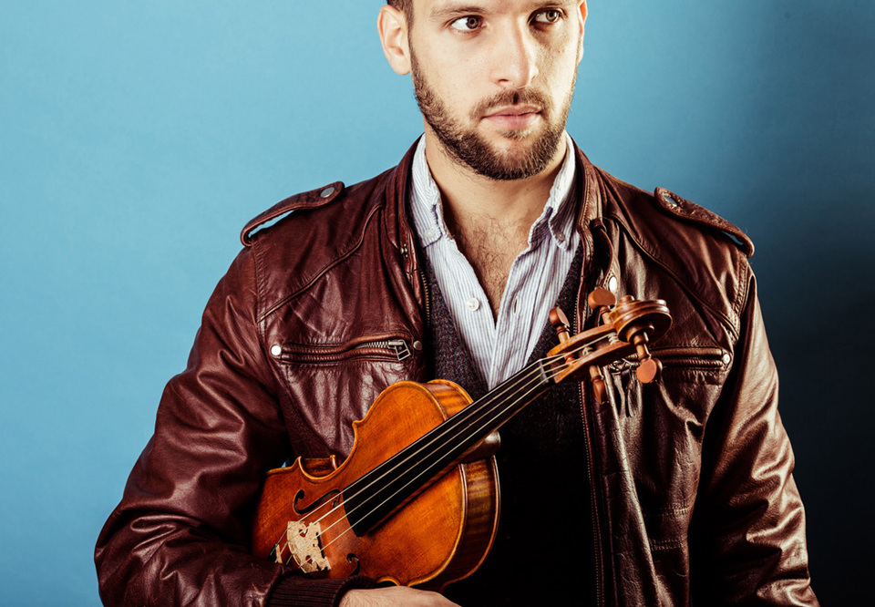 Man som håller i en violin. Fotografi.