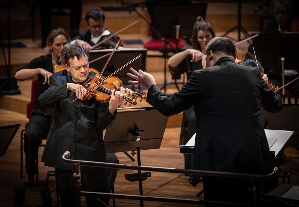 Man som spelar violin. Fotografi.