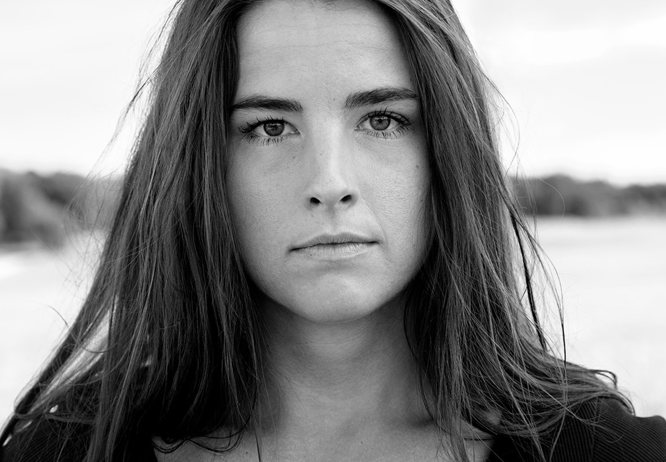 Svartvitt foto med kvinna med långt hår. Fotografi.