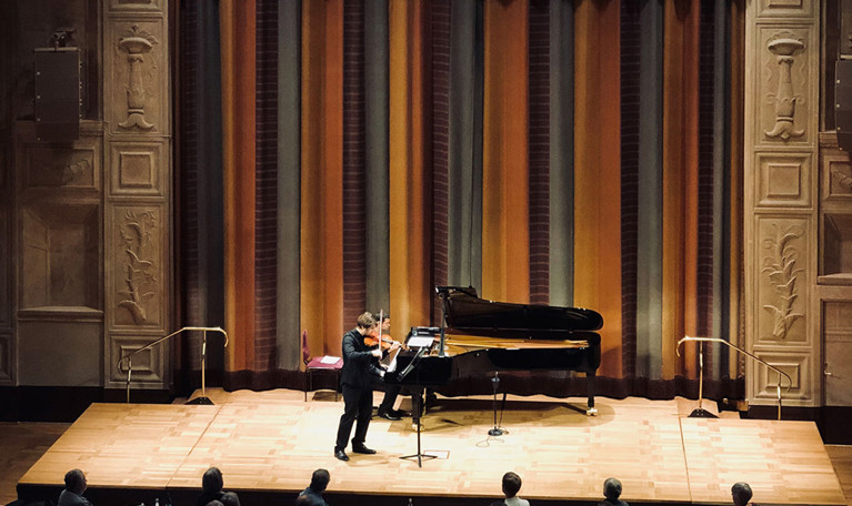 Man som spelar violin och en som spelar piano. Fotografi.