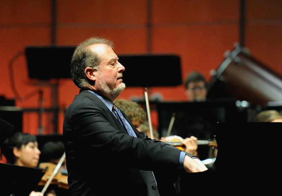 Garrick sitter vid sitt piano. Fotografi.