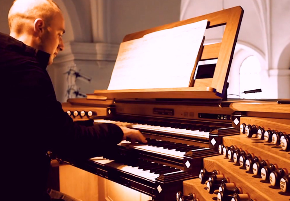 Man som spelar orgel. Fotografi.