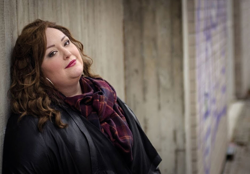 Womans leaning against a wall. Photo.