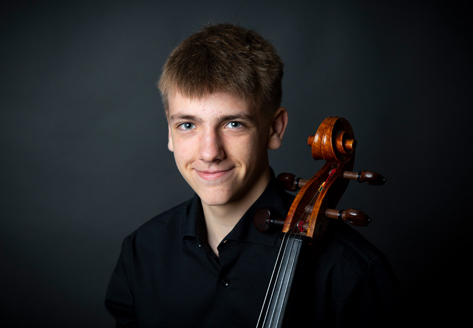 Ung kille med cello. Fotografi.