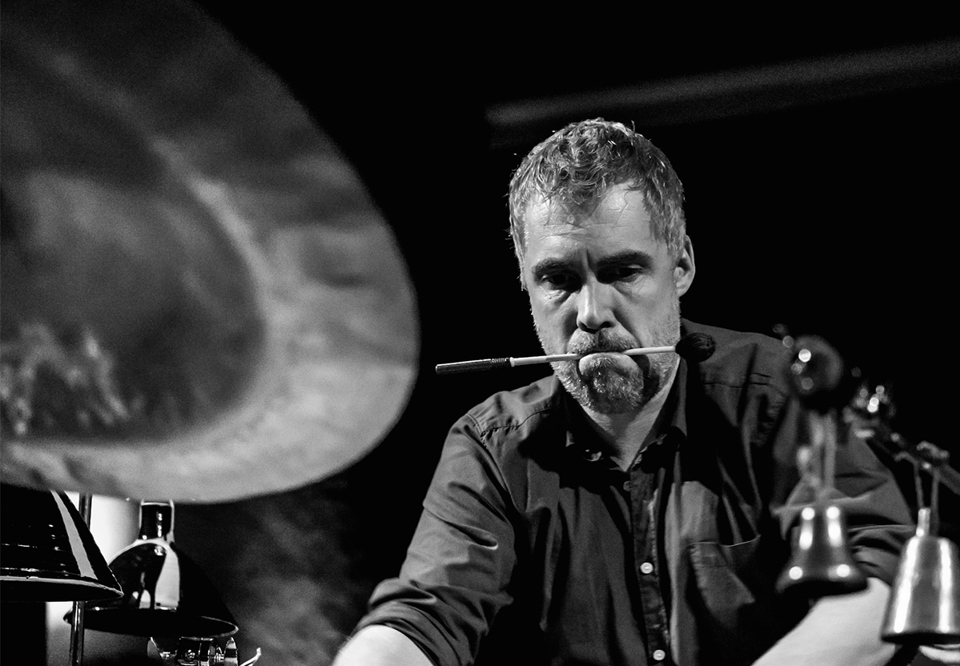 Black and white photo of a man playing  percussion.