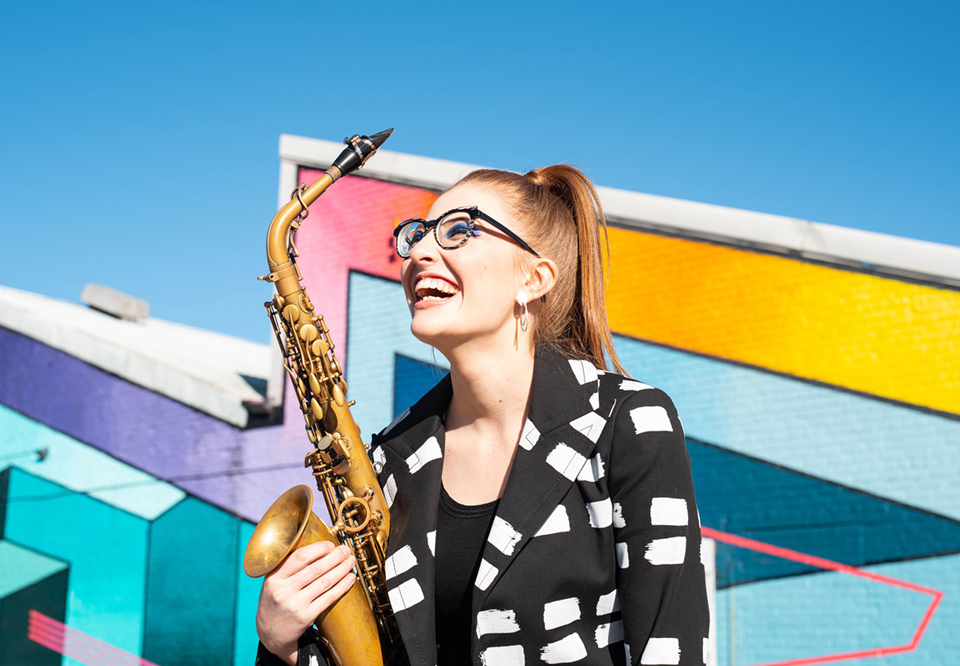 Närbild på kvinna med en saxofon. Fotografi.