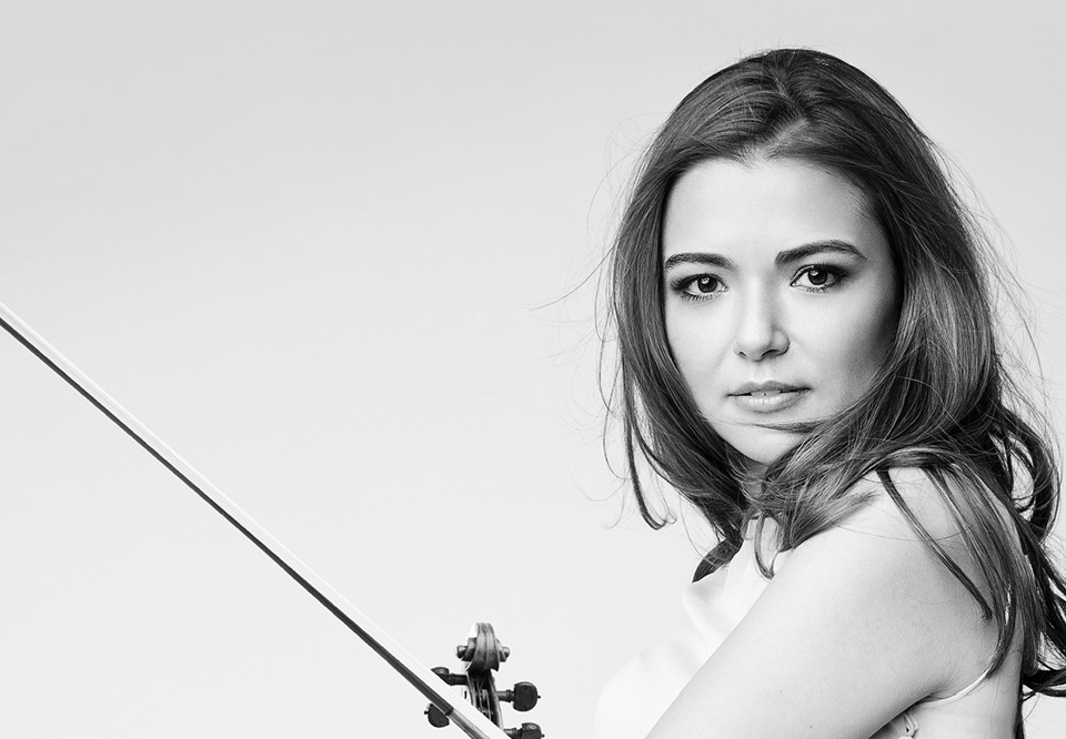 Kvinna som håller i en violin. Fotografi.