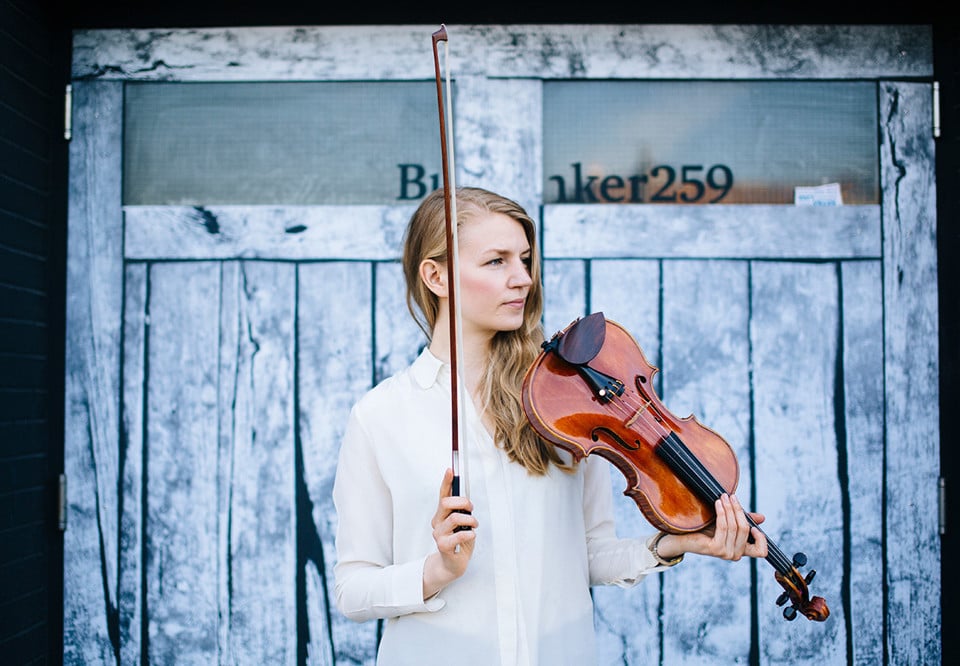 Kvinna som håller i en fiol. Fotografi.