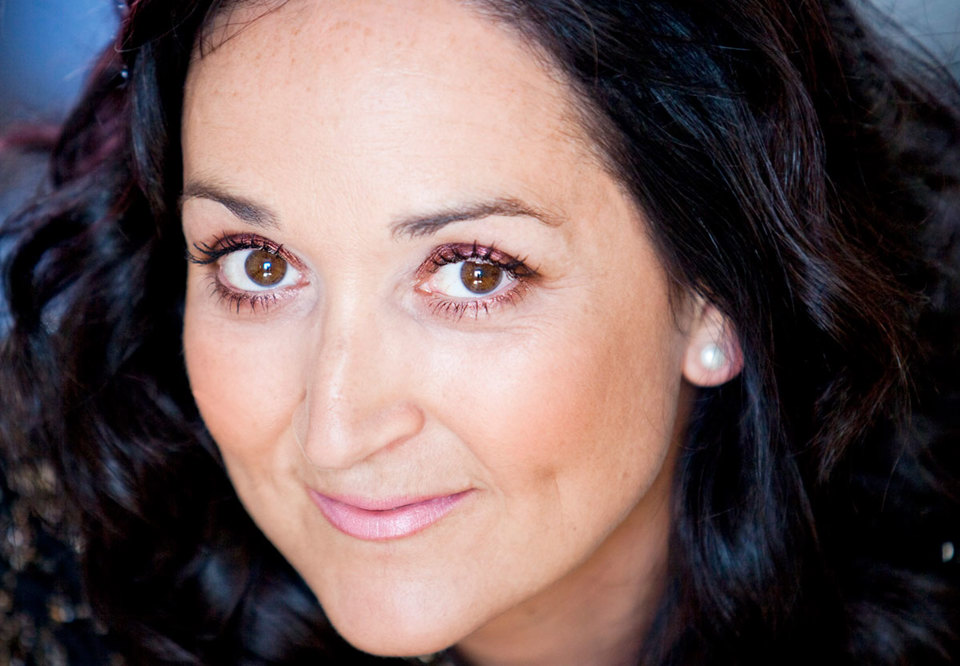 Woman with dark hair looing into the camera. Photo