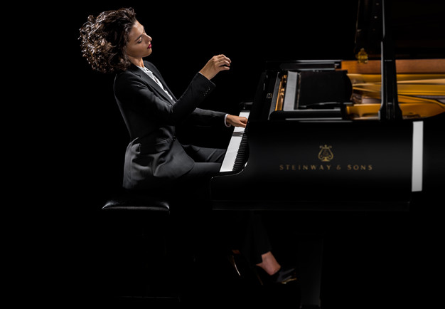 Kvinna vid ett piano. Fotografi.