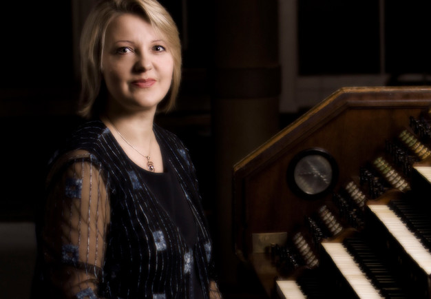 Kvinna vid en orgel. Fotografi.