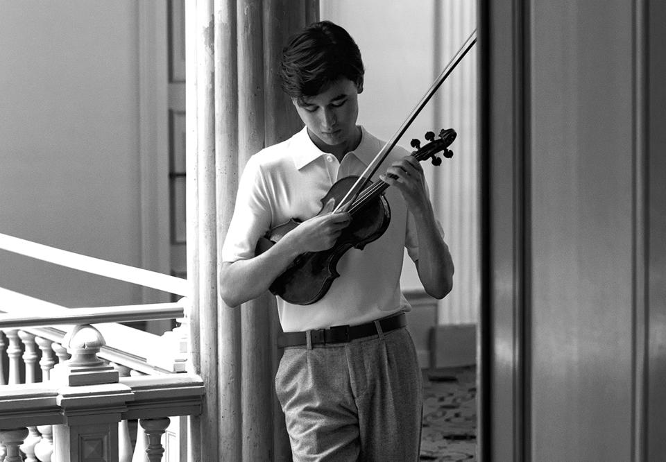 Ung man som spelar violin. Fotografi.