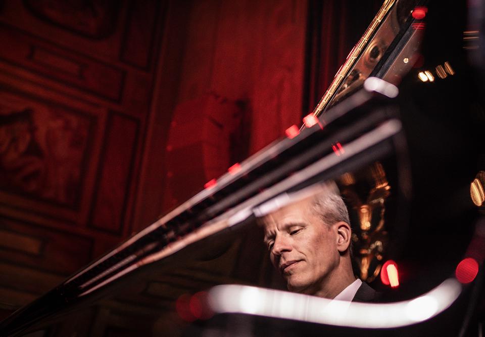 Man som spelar piano. Fotografi.