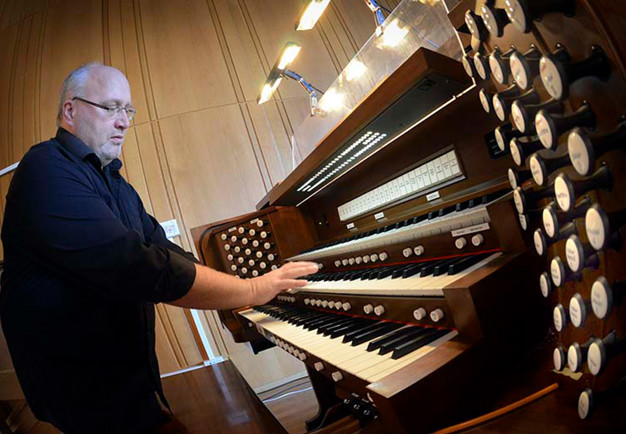 Man som spelar orgel. Fotografi.