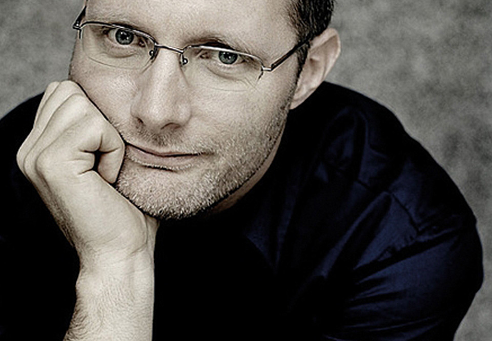 Man with black shirt with his chin inte hand. Photo.