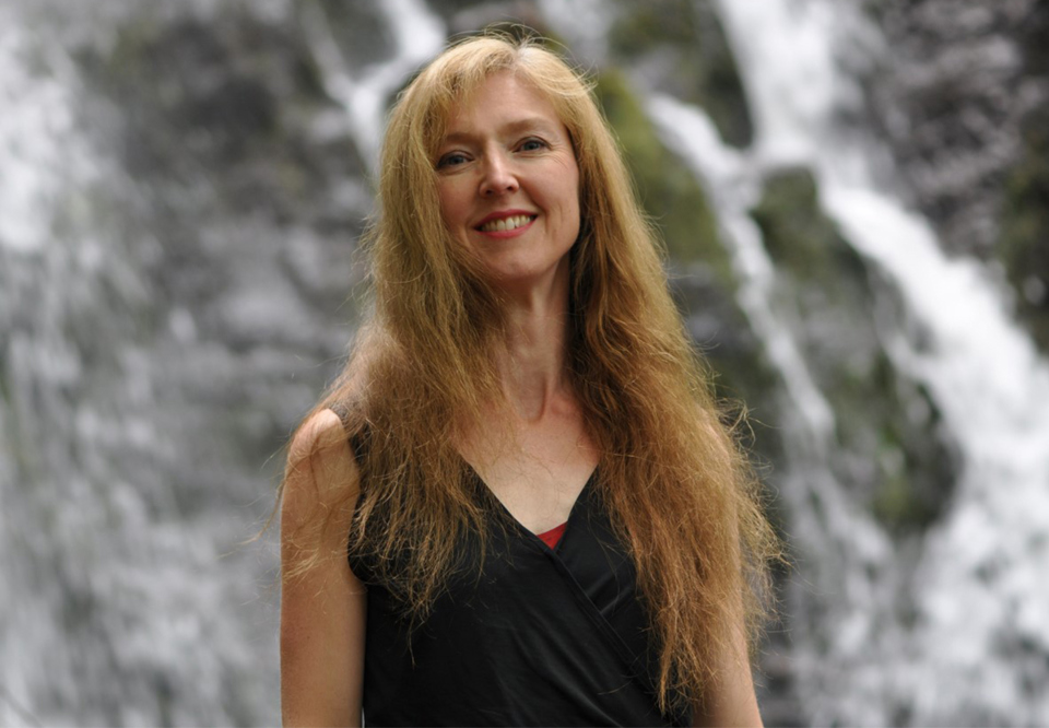 Woman with long hair in a photo outside. 