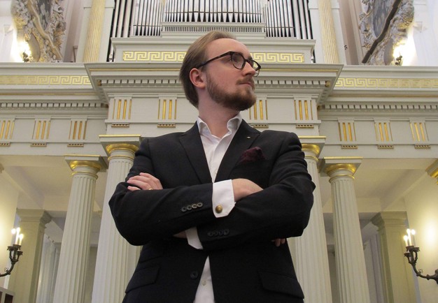 Close-up of man standing next to an organ. Photography.