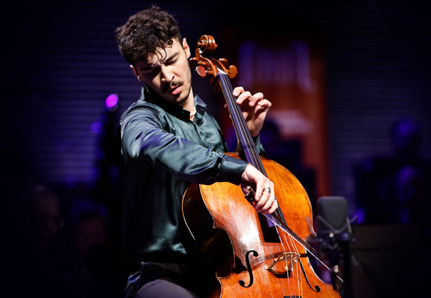 Man som spelar cello. Fotografi.