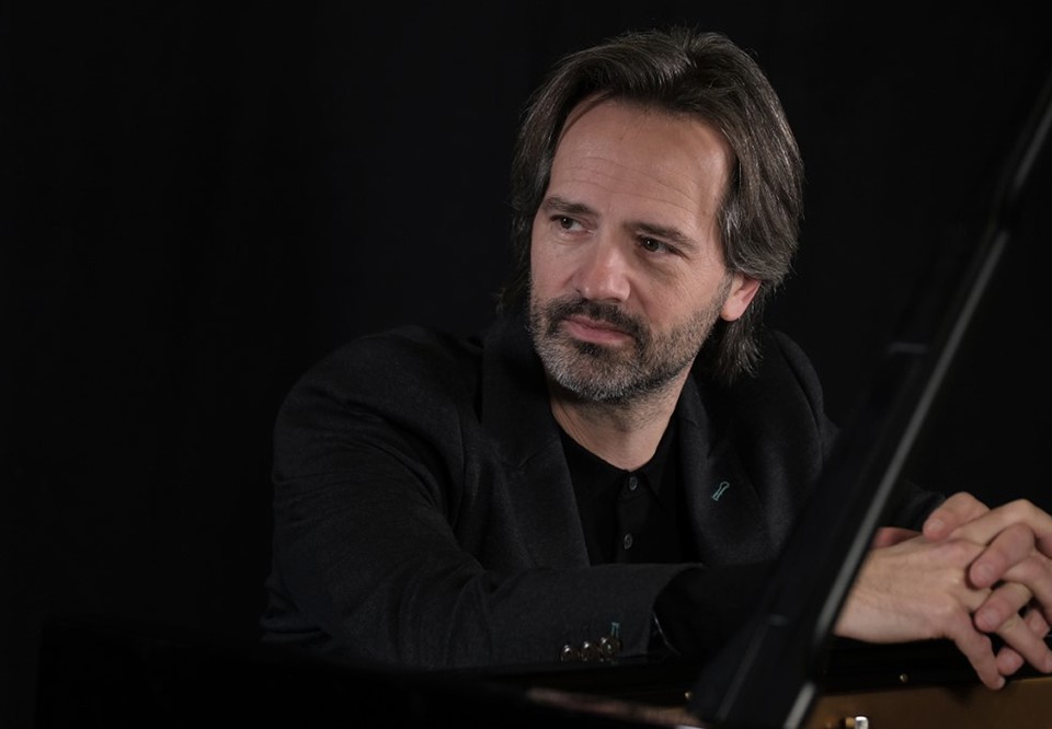 Man sitting by a piano. Photo