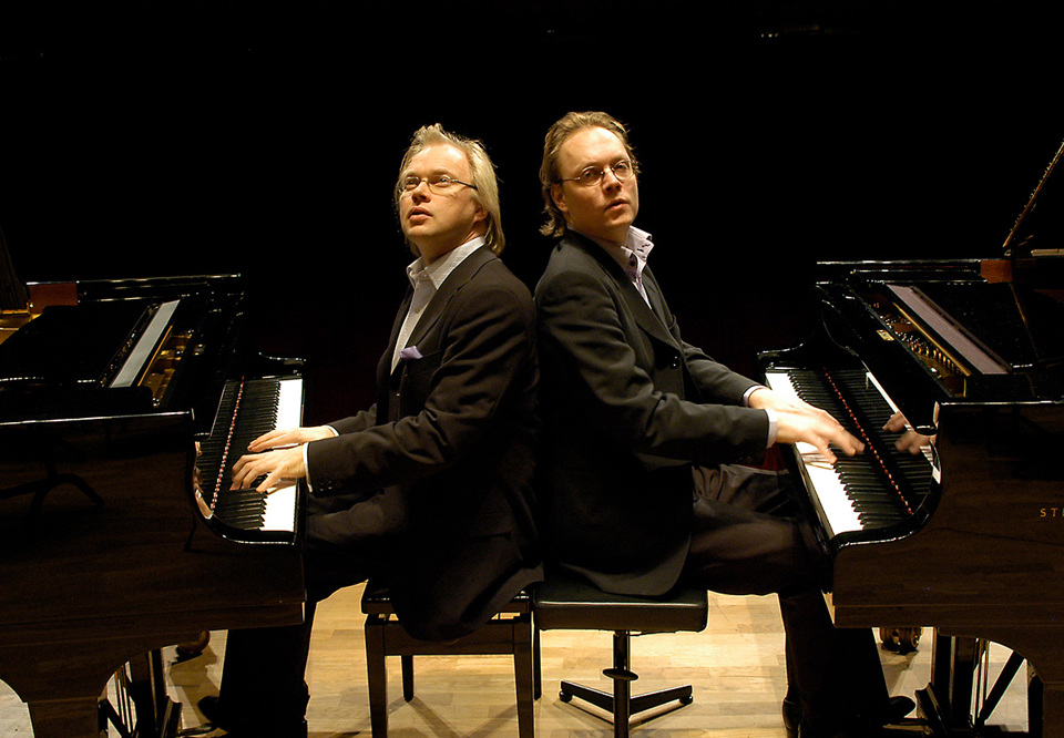 Två män som spelar piano. Fotografi.