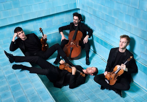 Fyra musiker med instrument. Fotografi.