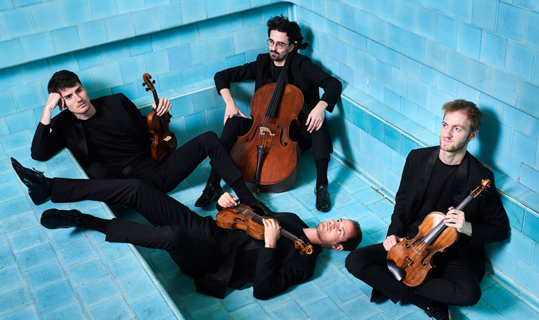 Fyra musiker med instrument. Fotografi.