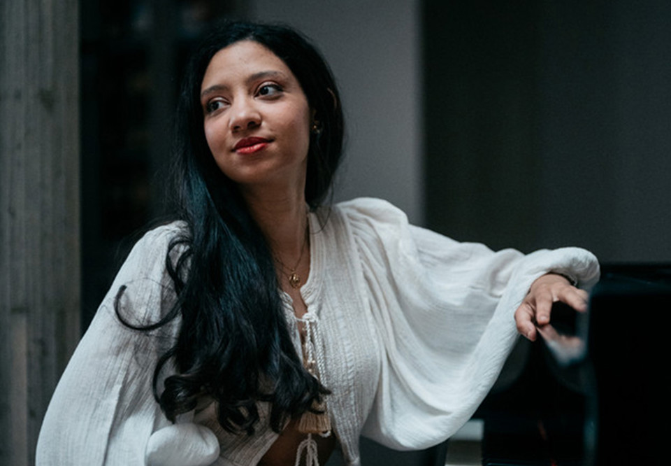 Kvinna vid piano. Fotografi.