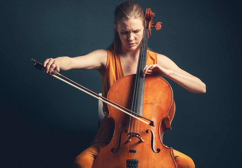 Kvinna som spelar cello. Fotografi.