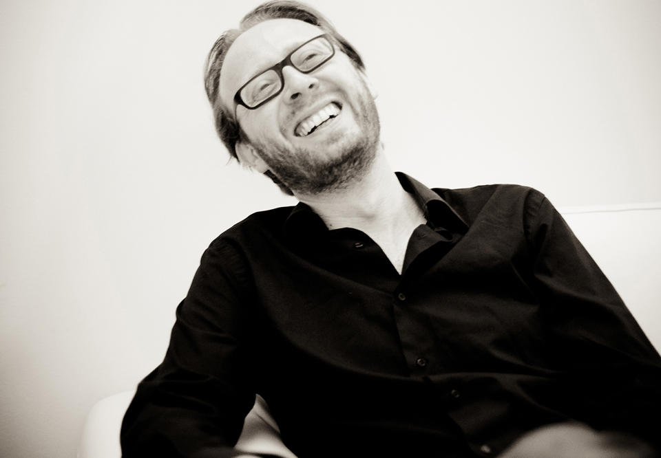 Svart vit bild på skrattande man med glasögon. Fotografi.
