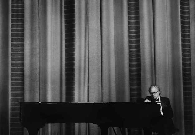 Man standing by the piano. Photo.