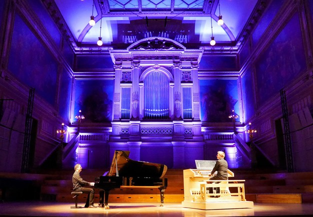 Två män som spelar orgel och piano. Fotografi.