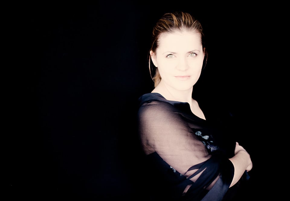 Woman standing in profile with dark clothes. Photography.