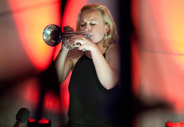 Kvinna som spelar trumpet. Fotografi.